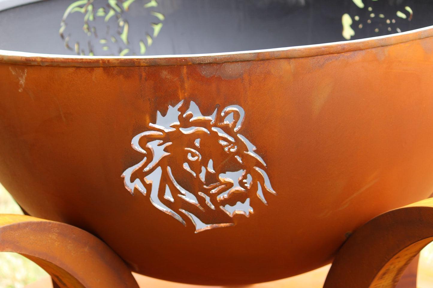 Detailed lion cutout on exterior of Africa’s Big Five patina fire pit by Fire Pit Art.