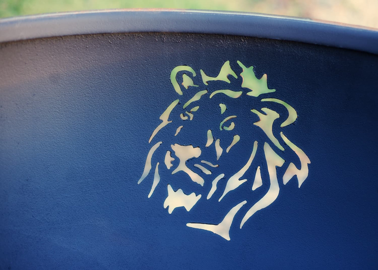 Interior view of lion's head cutout in steel fire pit bowl revealing expert craftsmanship by Fire Pit Art.