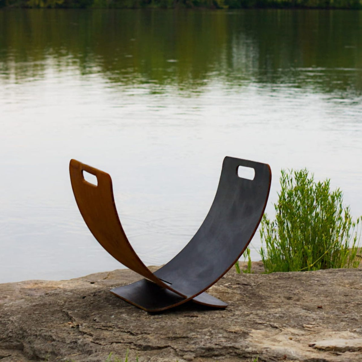 Sideview of Fire Pit Art’s Wings in Flight log rack. Made of carbon steel with patina finish.
