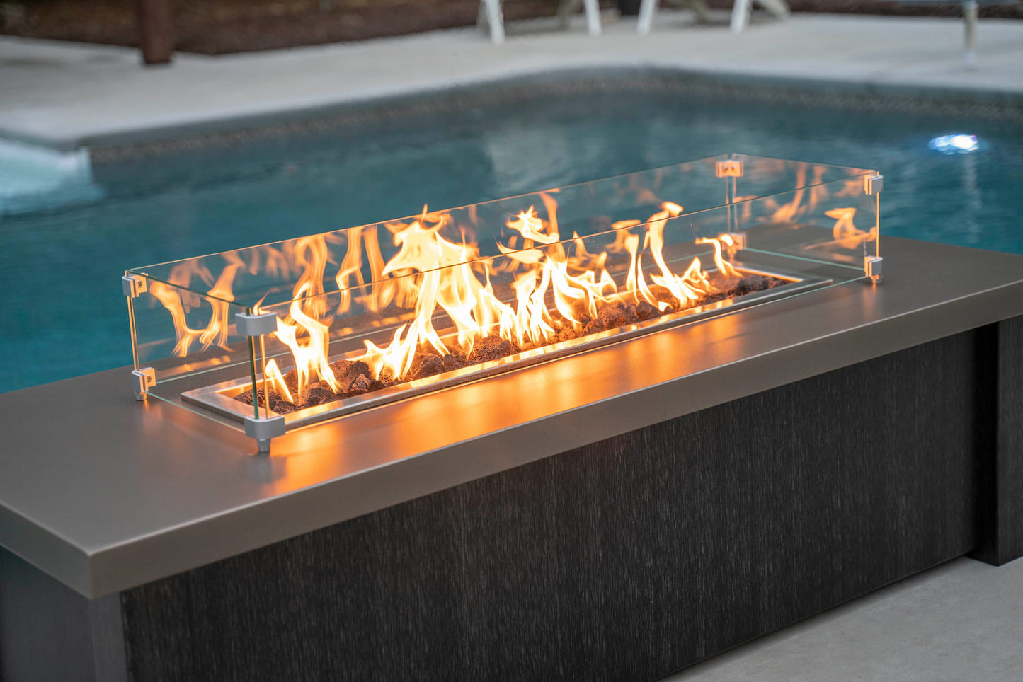 Close up over top of lit Carolina Evening Companion Propane Fire Table - Linear in Brushed Black (wind guard sold separately).