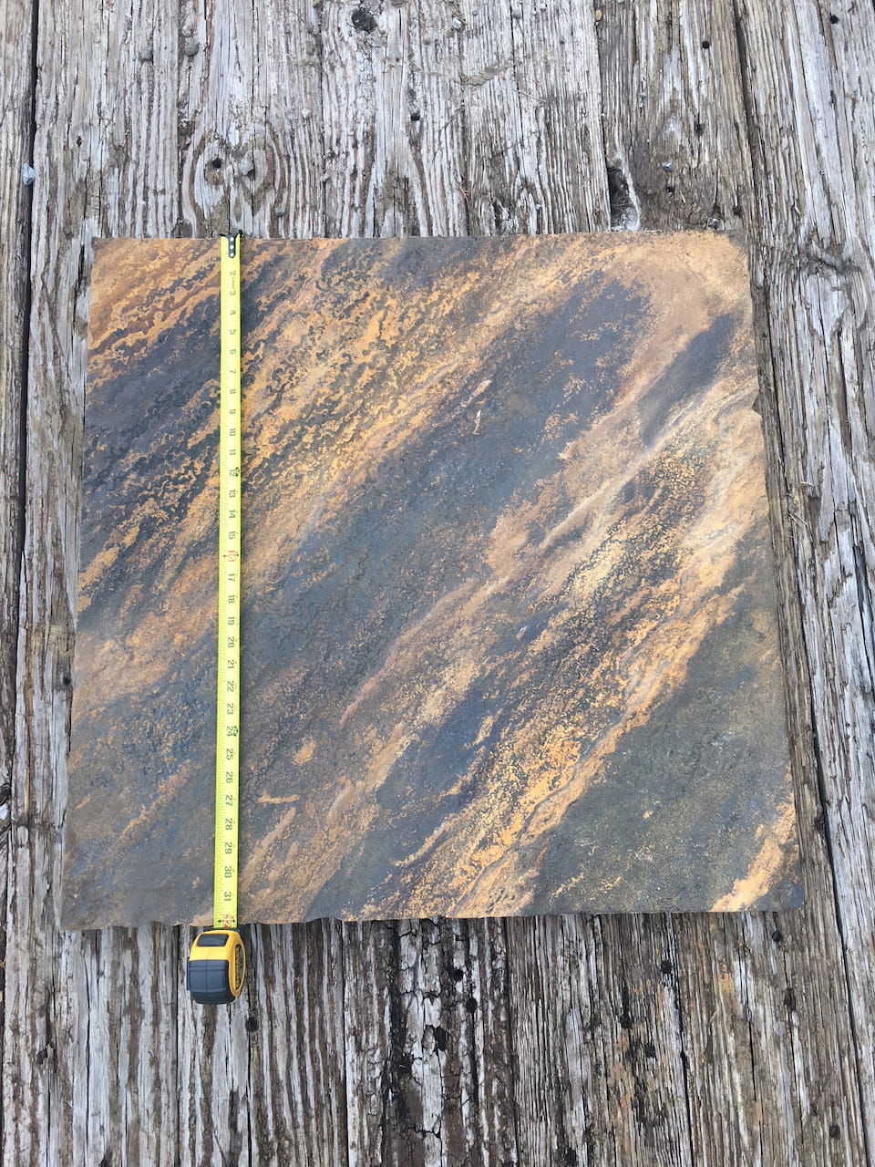 Square Crab Orchard stone base with a yellow tape measure across the surface, highlighting its size and natural grain patterns.