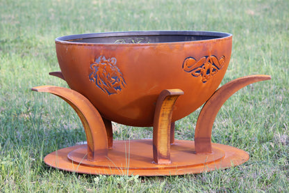Side view of Africa’s Big Five fire pit with animal designs, unlit in outdoor setting. By Fire Pit Art.