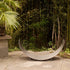 Sideview of Fire Pit Art’s stainless steel crescent-shaped log rack on patio.