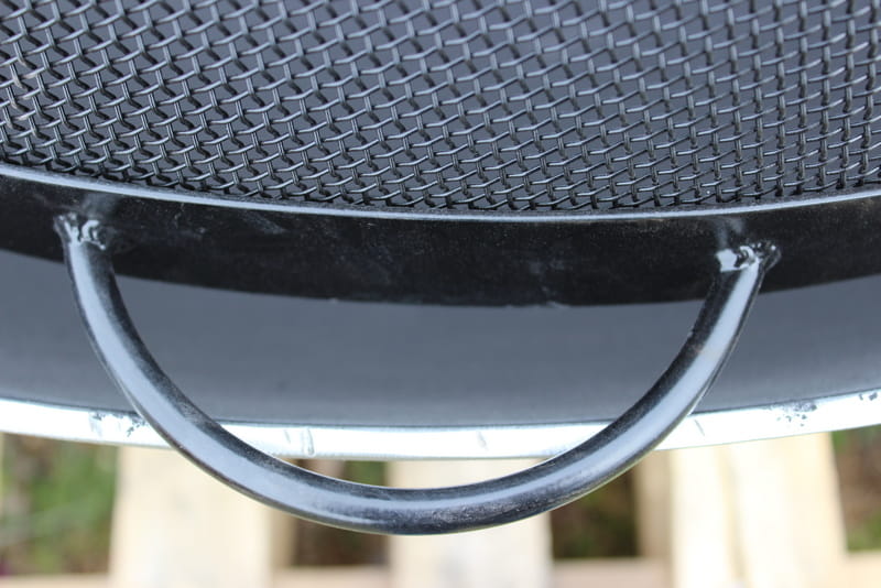 Close-up of steel carrying handle on the side of 44.5” black heavy stainless steel mesh Spark Guard by Fire Pit Art (fits Bella Vita 46” and Asia 48 , each sold separately).