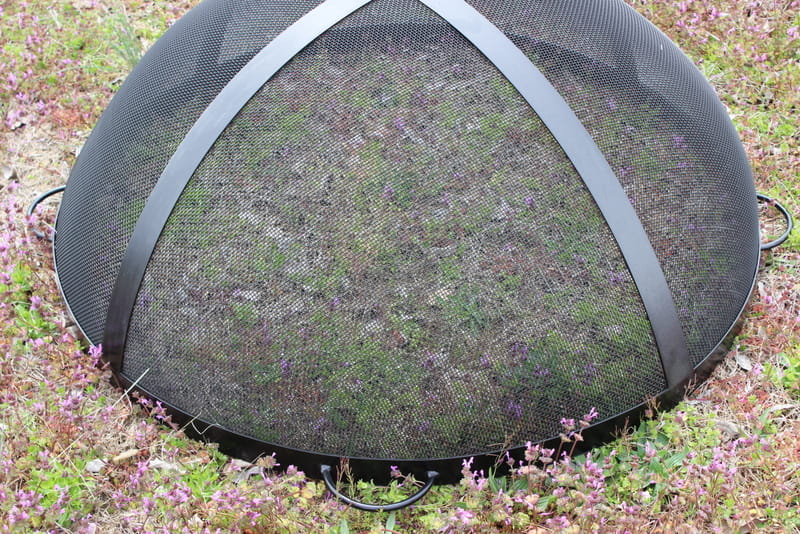 44.5” black heavy stainless steel mesh Spark Guard with two-inch wide 304 stainless steel bands sitting by itself on the grass.  Fits Fire Pit Art styles: Bella Vita 46” and Asia 48” (sold separately).
