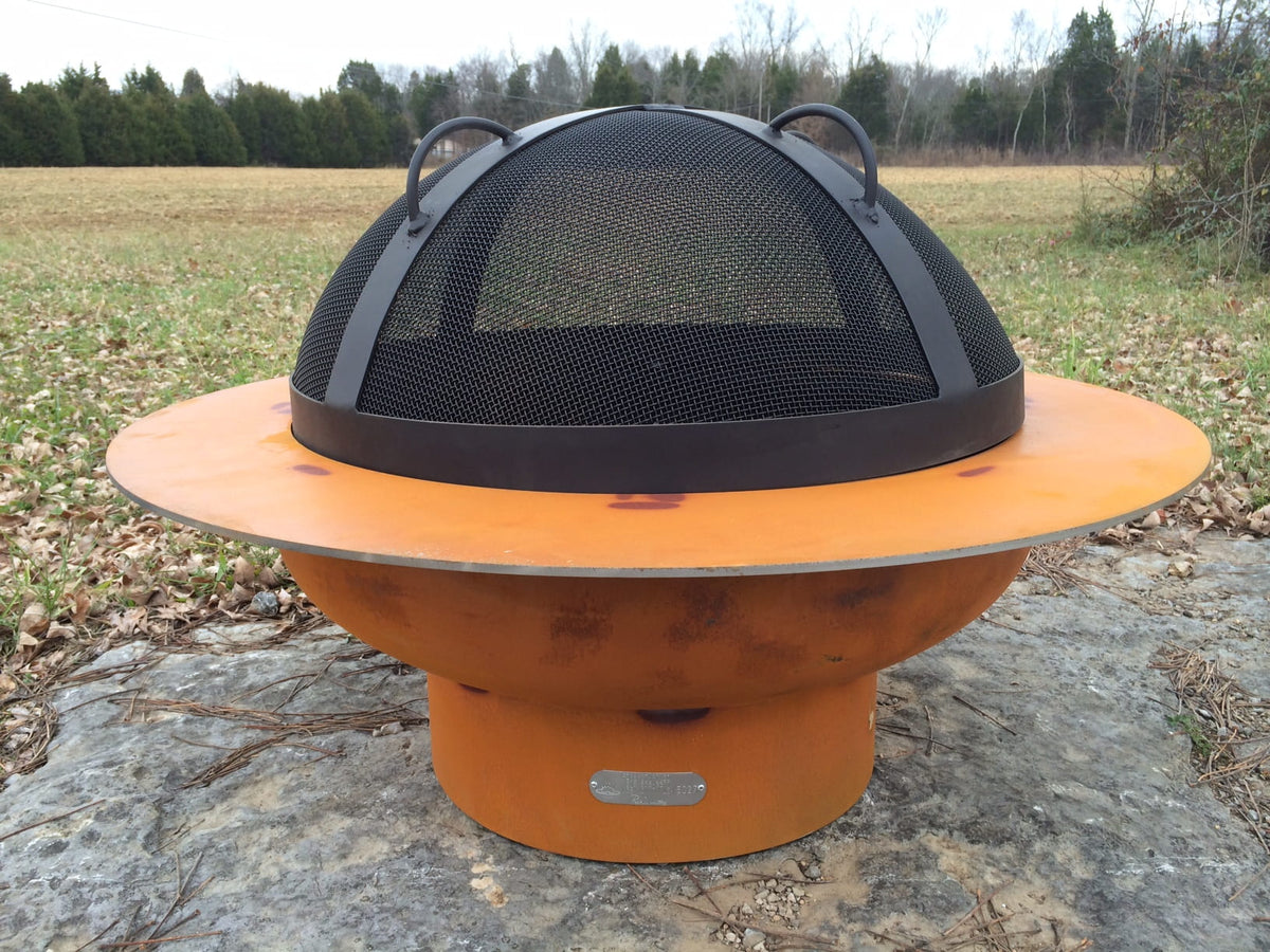 Fire Pit Art’s Saturn fire pit with the 27.5” black heavy stainless steel mesh Spark Guard with two-inch wide 304 stainless steel bands on top of fire pit (fire pit sold separately).