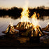 Three Asia Steel Fire Pits in varying sizes with wood burning at dusk.