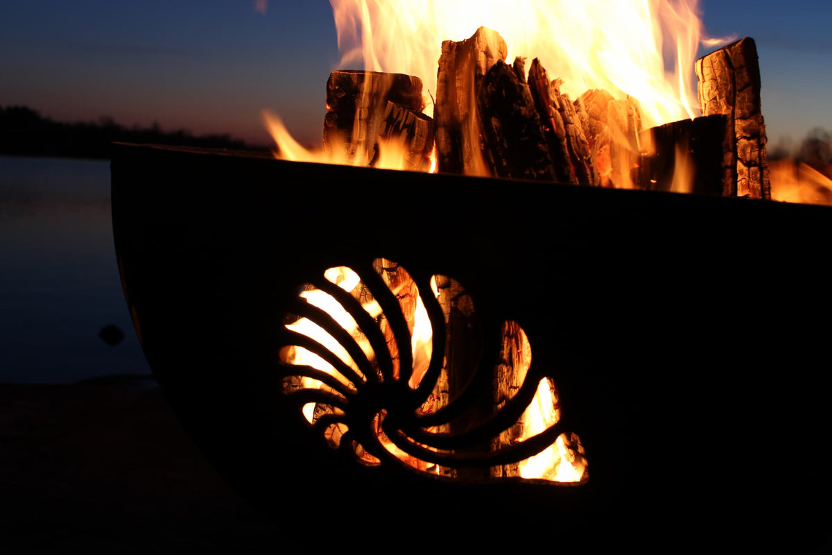 Close-up of shell cutout glowing from fire inside the Beachcomber 36" fire pit. Made in the USA.