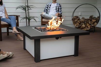 Close up of lit Carolina Evening Companion Square fire table in use during evening gathering, fire glowing warmly on patio (shown in Endura Charcoal and White).