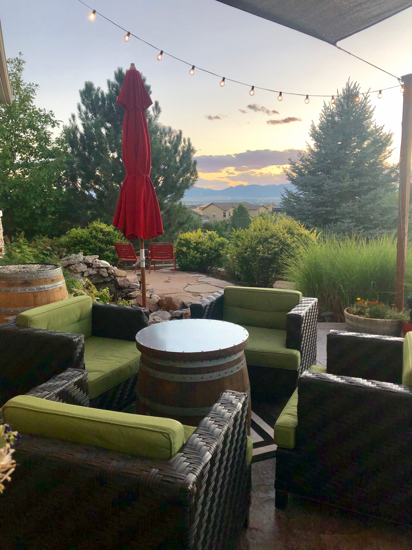 Wine barrel coffee table with matching lid on an outdoor patio at sunset with wicker seating and mountain view.