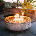Fire Surfer steel fire pit with bright flame on patio at sunset.  Made in the USA by Fire Pit Art.