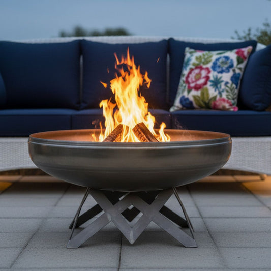 The Liberty Fire Pit - Angular Base - with flames in an patio setting in front of a couch and pillows.