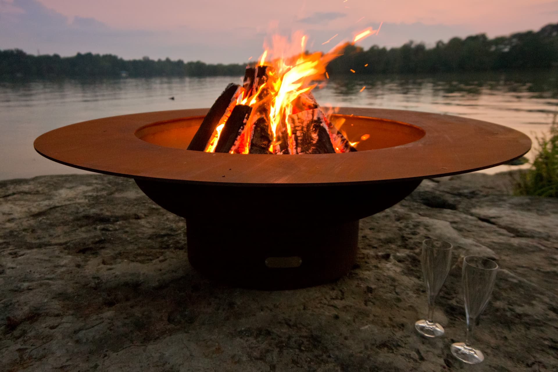 Magnum 54" carbon steel fire pit with tall flames during golden hour.  Made in USA by Fire Pit Art.