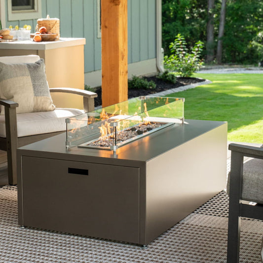 Lit Milan Linear propane fire pit table in Endura Concrete on a patio.  Made in the USA.  Wind shield sold separately.
