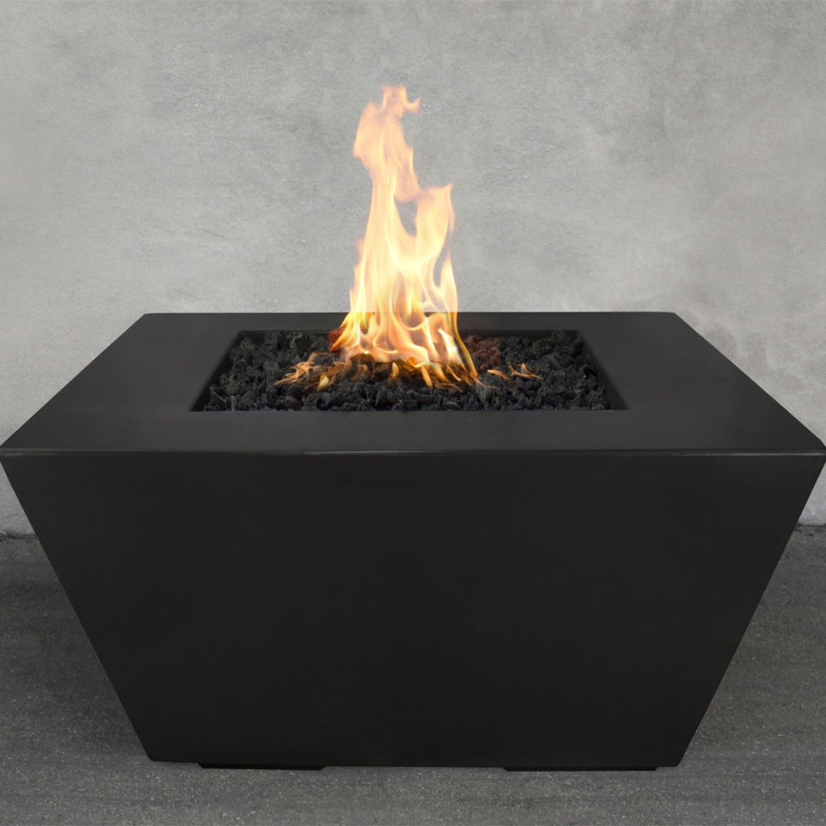 Redan GFRC Concrete black fire pit with flames on a gray concrete background