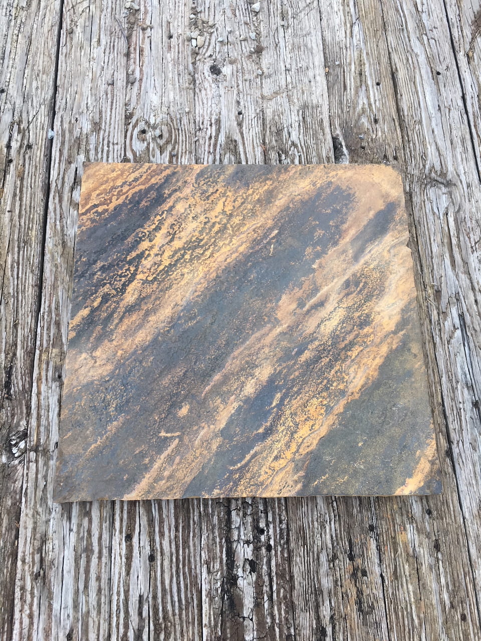 Single Crab Orchard stone base resting on a weathered wooden surface, displaying organic streaks of gold, brown, and gray.