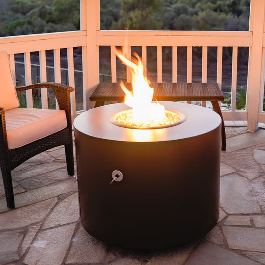 The lit Beverly round steel fire pit in copper vein powder coat on a patio.