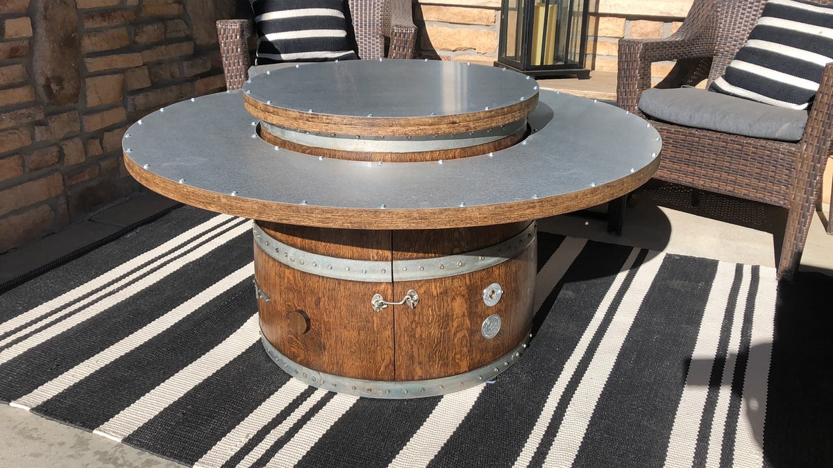 Wine barrel coffee table fire pit with lid closed on patio with chairs – doubles as a sturdy outdoor table when the fire is not in use.  Made in the USA.